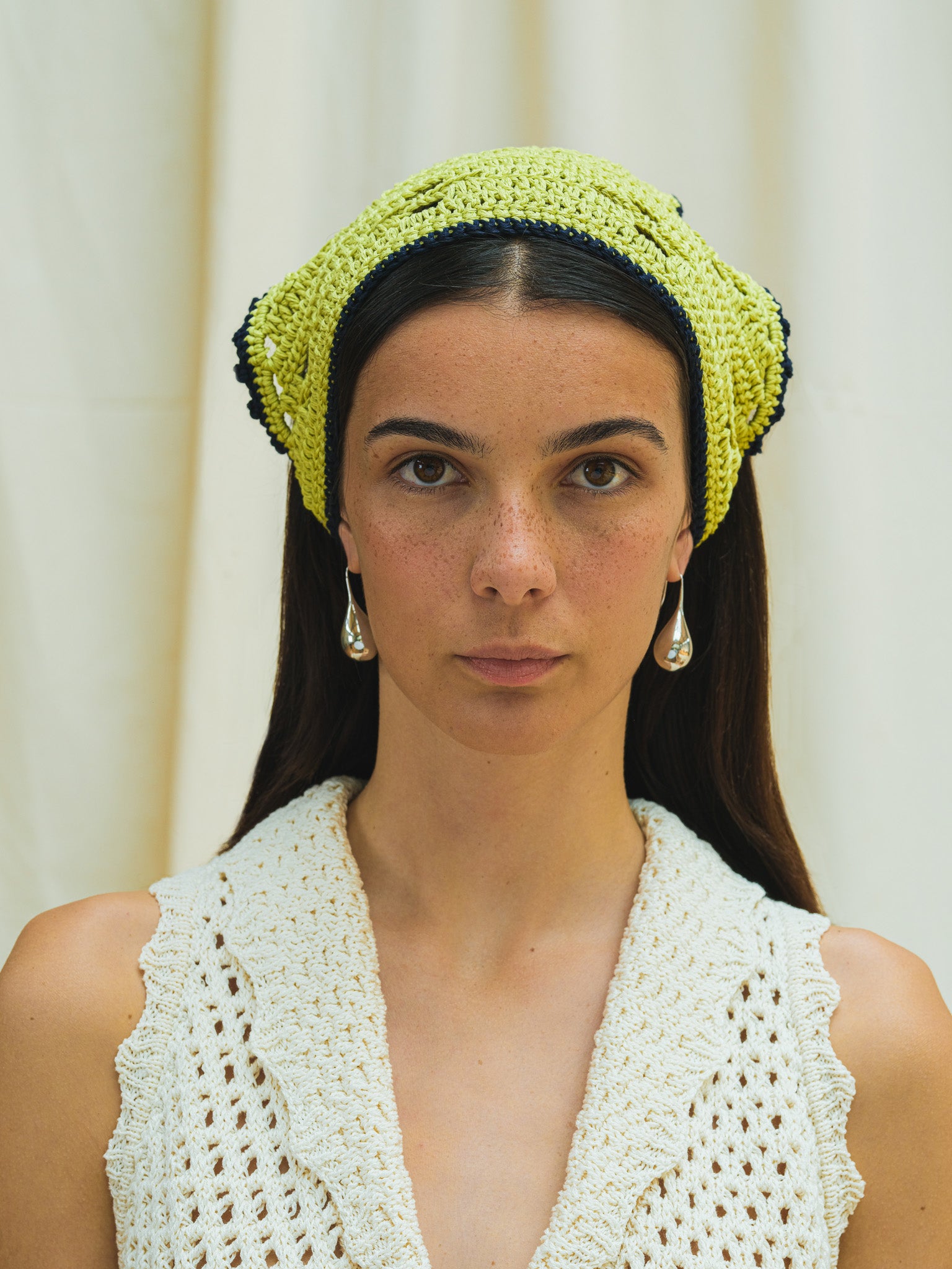 Front view of hand crocheted bandana in pistacchio with navy trim.