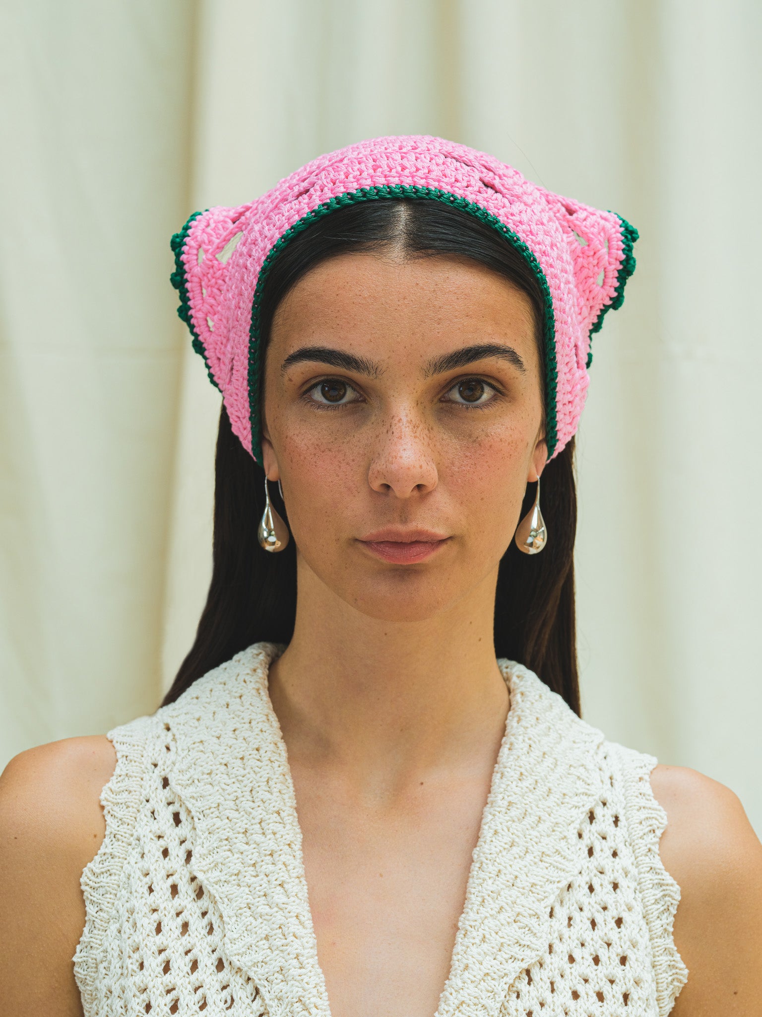 Front view of hand crocheted bandana in peony pink with emerald trim.