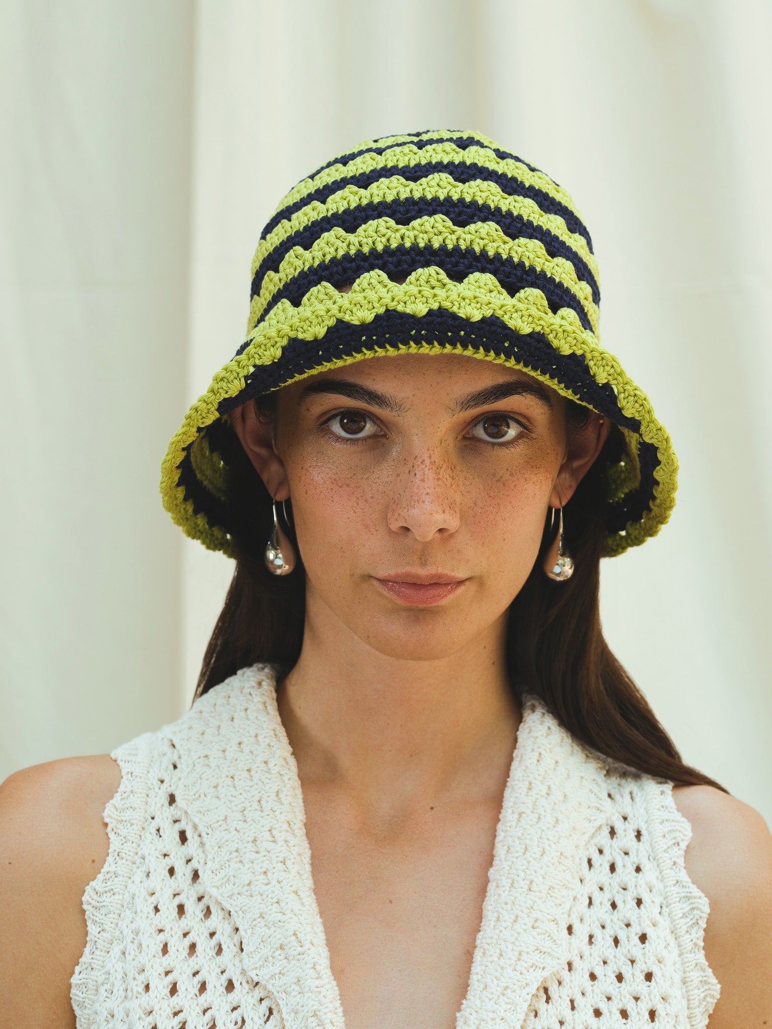 Front view of hand crocheted shell sun hat in pistachio and navy stripe