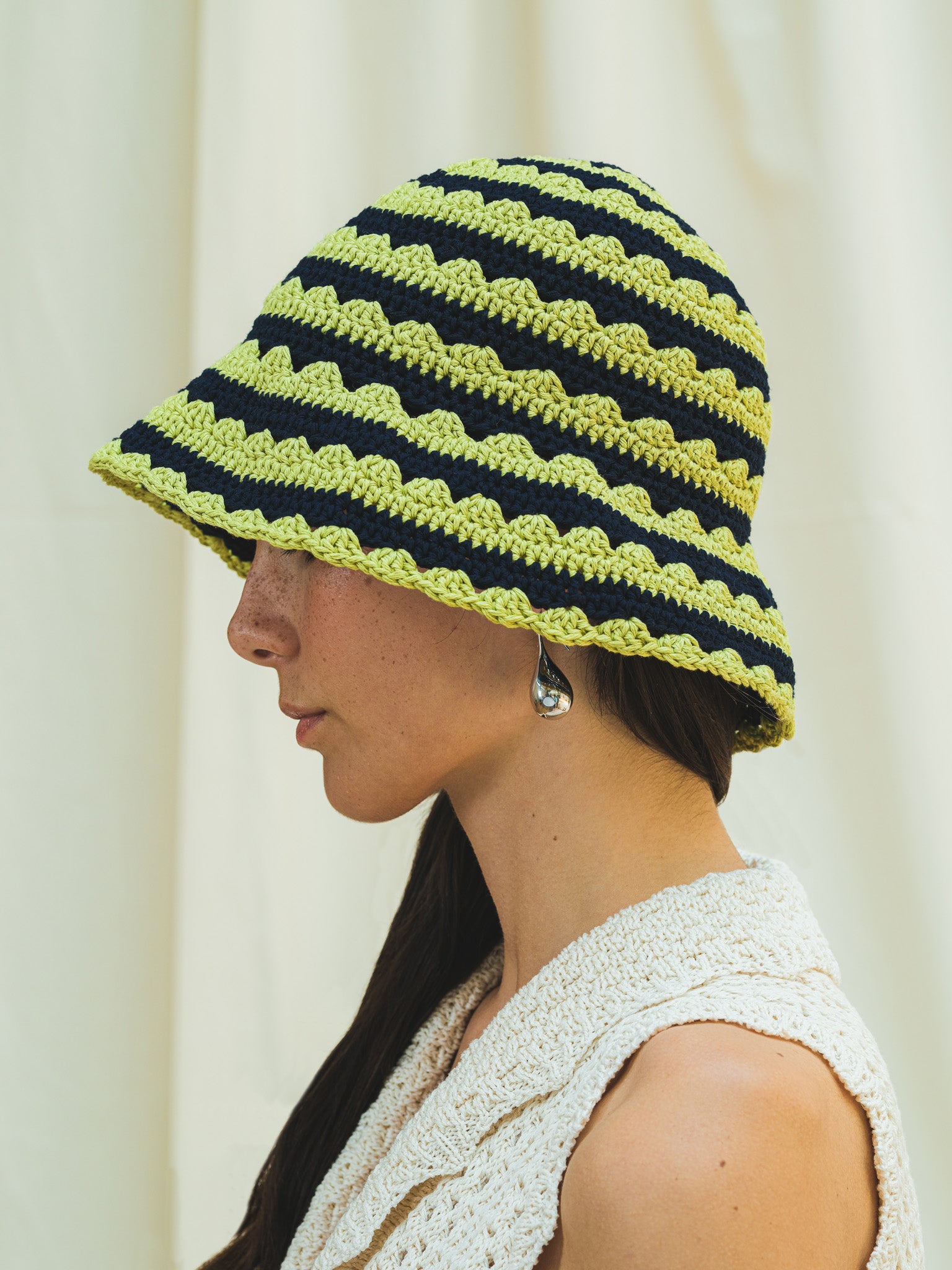 Side view of hand crocheted shell sun hat in pistachio and navy stripe