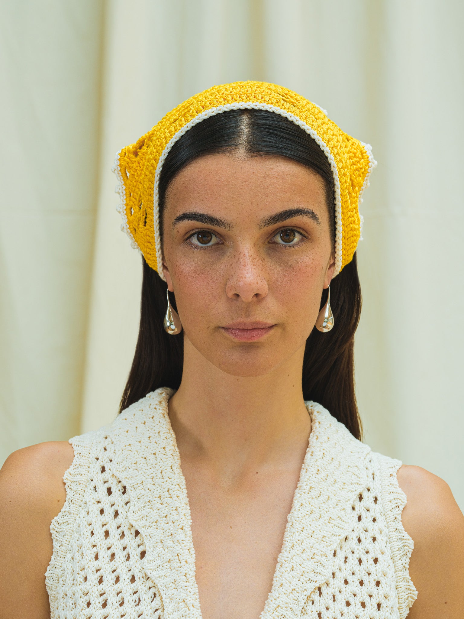 Front view of hand crocheted bandana in capri yellow and with linen white trim.