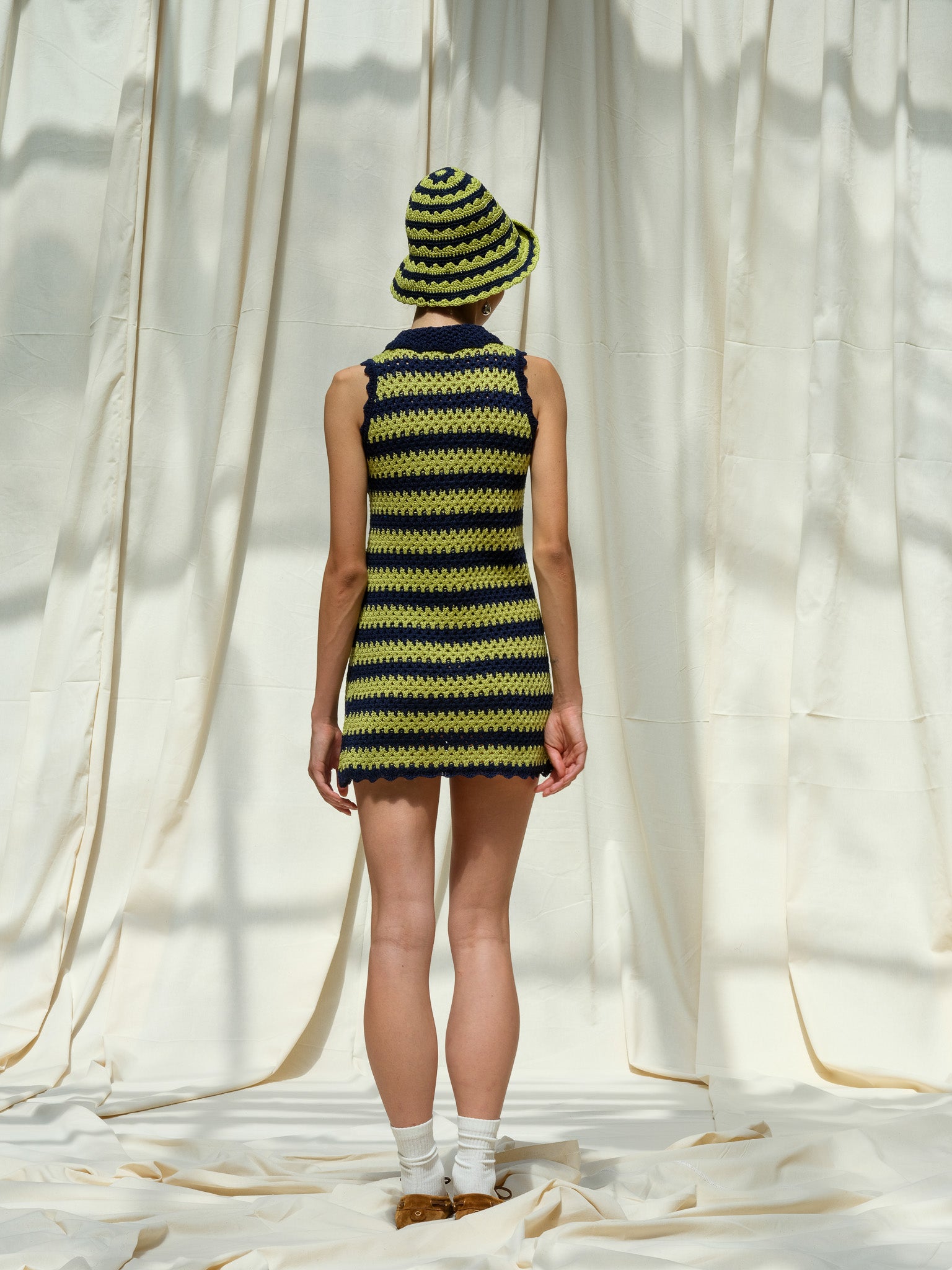 Back view of navy and pistachio striped mini dress showing scallop edge detail