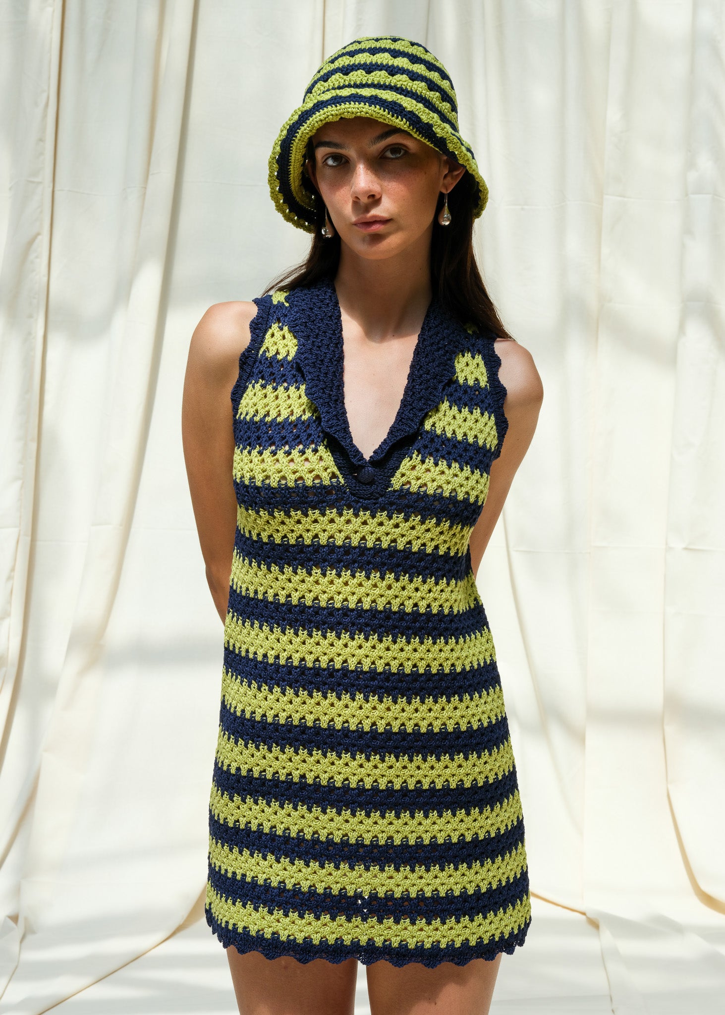 Front view of hand knitted navy and pistachio striped mini dress with scallop edges