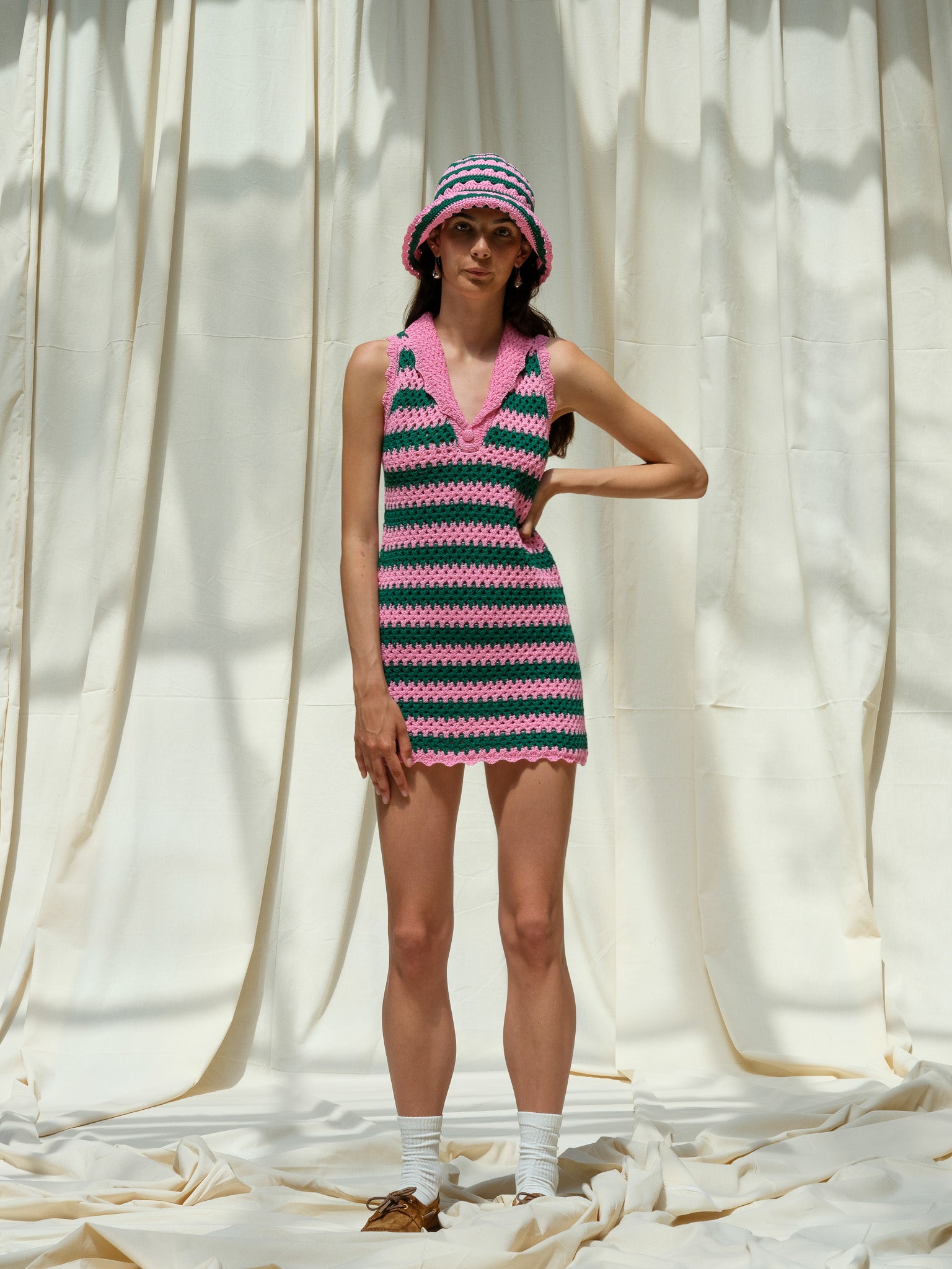 Front view of hand knitted peony pink and dark emerald striped mini dress
