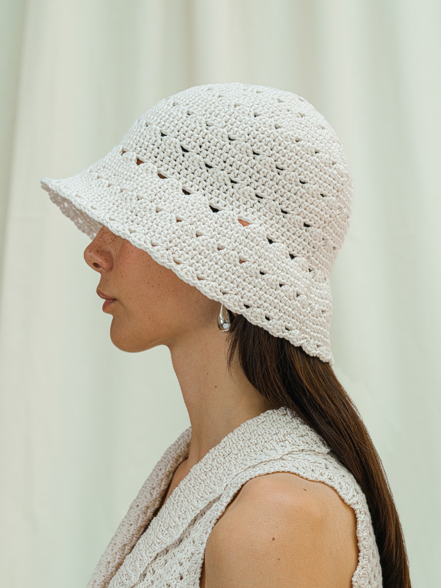 Side view of hand crocheted shell sun hat in linen white